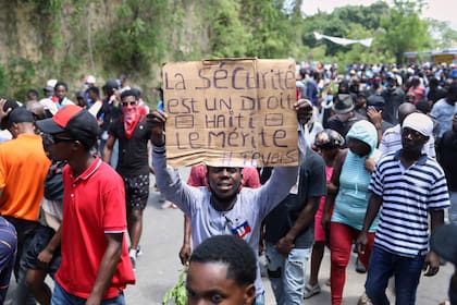 Un manifestante sostiene una pancarta con la leyenda en francés: "La seguridad es un derecho, Haití lo merece", el 2 de abril de 2025, en Puerto Príncipe, Haití