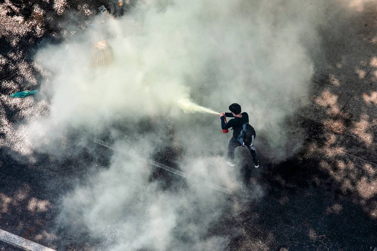 Un manifestante usa un extintor de incendios mientras las fuerzas de seguridad reprimen las manifestaciones contra el golpe militar en Yangon, Myanmar, el 28 de febrero de 2021