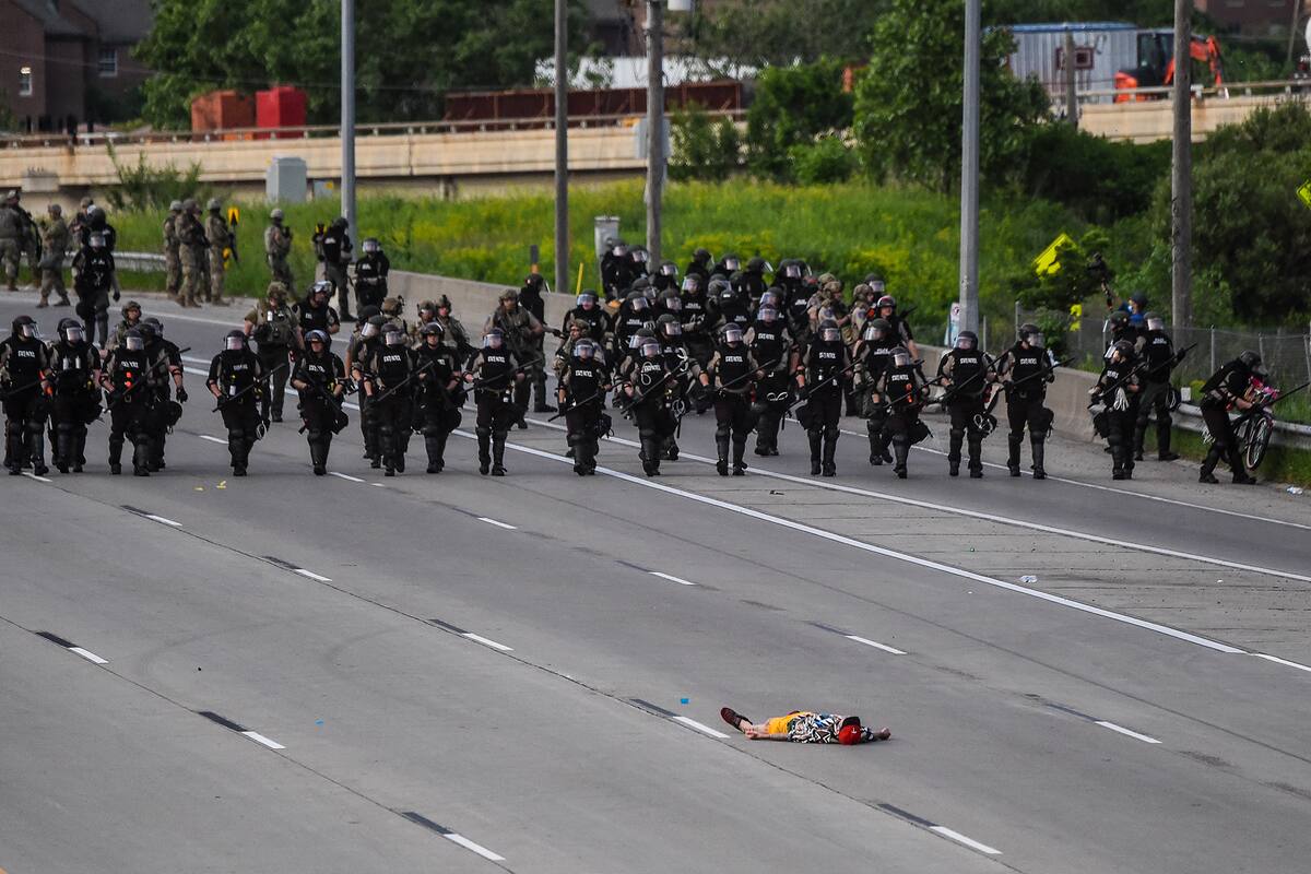 Un manifestante yace en la carretera frente a la línea policial durante una protesta por la muerte de George Floyd el 31 de mayo de 2020 en Minneapolis, Minnesota