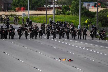 Un manifestante yace en la carretera frente a la línea policial durante una protesta por la muerte de George Floyd el 31 de mayo de 2020 en Minneapolis, Minnesota
