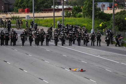 Un manifestante yace en la carretera frente a la línea policial durante una protesta por la muerte de George Floyd el 31 de mayo de 2020 en Minneapolis, Minnesota