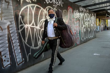 Un mariachi mexicano con un tapabocas camina cerca de la Plaza Garibaldi en la Ciudad de México el 5 de febrero de 2021, en medio de la pandemia de coronavirus