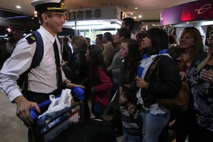 Un marino evacuado se reencuentra con sus familiares en el aeropuerto de Ezeiza.