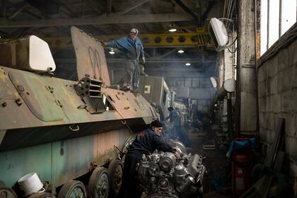 Un mecánico arregla el motor de un vehículo blindado de transporte de tropas ucraniano en un taller de reparación de tanques en la región de Kiev, Ucrania, el 20 de octubre de 2023