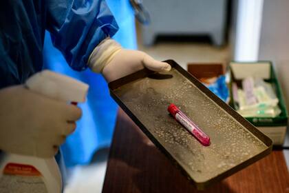 Un médico prepara una muestra de hisopado para ser analizada en el Hospital Eurnekian de Ezeiza.