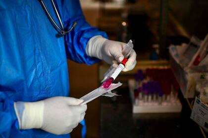 Un médico prepara una muestra de hisopado para ser analizada en el Hospital Eurnekian de Ezeiza.