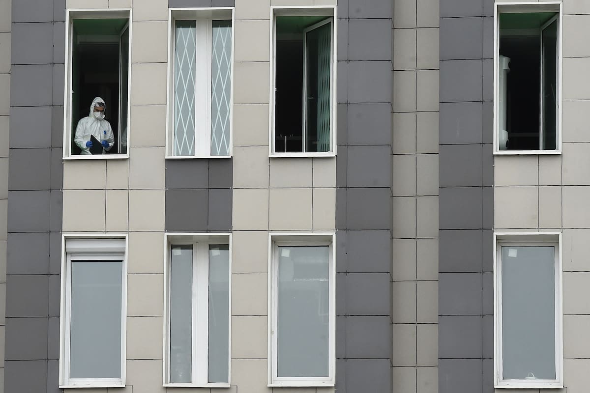 Un médico que usa equipo de protección mira desde una ventana del hospital Saint George en San Petersburgo el 12 de mayo de 2020, en medio de la pandemia de coronavirus