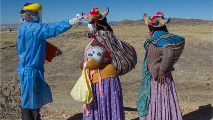 Un médico toma la temperatura a dos mujeres en el área rural de Perú