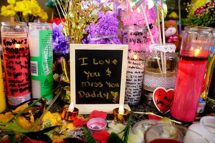 Un mensaje dejado para una de las víctimas de un reciente tiroteo masivo se encuentra entre flores y velas en un memorial el sábado 9 de abril de 2022 en Sacramento, California. (AP Foto/Rich Pedroncelli)
