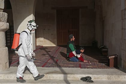 Un miembro de la Defensa Civil de Siria desinfecta una mezquita, al norte de Aleppo, como parte de las medidas sanitarias dispuestas por el gobierno, el 24 de marzo de 2020