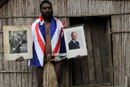 Un miembro de la tribu de Yaohnanen, en la isla Tanna, con fotografías del príncipe Felipe que hoy se consideran reliquias