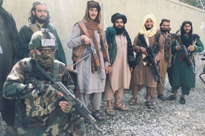 Un miembro de una "unidad roja" talibán (arrodillado, abajo a la izquierda) posa con otros talibanes en Balkh