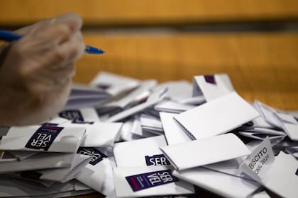 Un miembro del personal electoral cuenta los votos después del cierre de las urnas en la escuela secundaria Amunategui en Santiago el 25 de octubre de 2020, durante la votación del referéndum constitucional