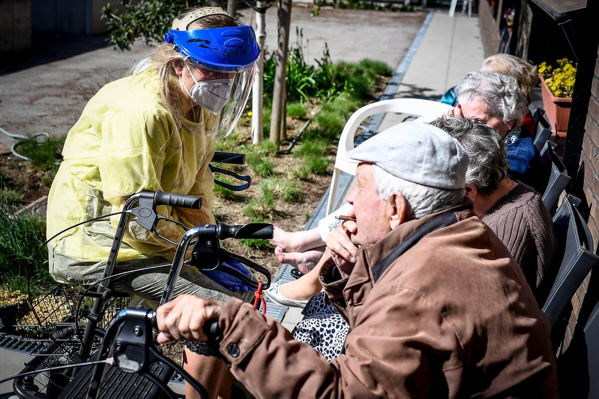Un miembro del personal habla con los residentes de una casa de retiro en Deerlijk, Bélgica, donde se reúnen las personas diagnosticadas con síntomas del coronavirus, el 21 de abril de 2020