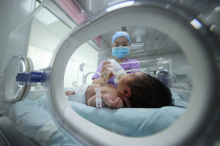 Un miembro del personal médico alimenta a un bebé en un hospital al suroeste de China