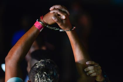 Un migrante colombiano levanta las manos esposadas antes de subir a un avión de deportación (AP Foto/Agustín Herrera)