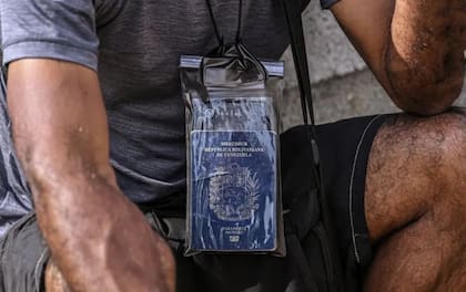 Un migrante protege su pasaporte con plástico en el campamento de Lajas Blancas, al salir de la selva del Darién en Panamá.