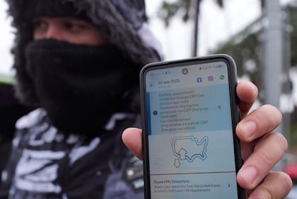 Un migrante que solicita asilo muestra la app CBP One mostrando su cita cancelada