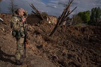 Un militar ucraniano inspecciona un lugar tras un ataque aéreo de fuerzas rusas en Bahmut, Ucrania, el martes 10 de mayo de 2022. (AP Foto/Evgeniy Maloletka)