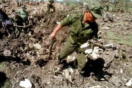 Un militar uruguayo rescata una pieza del DC9 en el cráter que dejó su caída