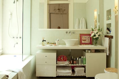 Un mueble de melamina enchapada sostiene la bacha. El espejo tiene el marco laquedo para una combinación perfecta.