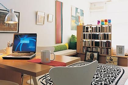 Un mueble modular se va transformando en su recorrido por este monoambiente para unificar el estilo y aprovechar metros al sumar funciones.