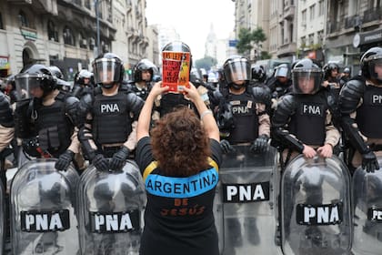 Un mujer enfrenta a la policía con un libro en sus manos