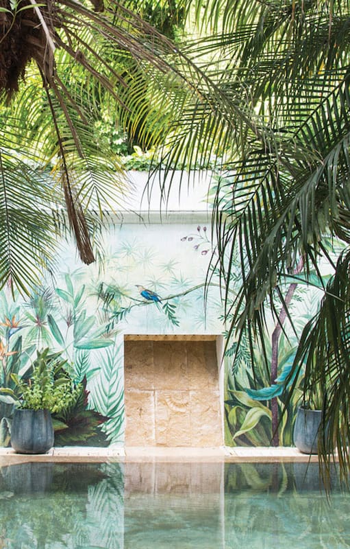 Un mural de Male Inurrigarro viste la medianera del fondo de un jardín diseñado por la paisajista Martina Zavalía.