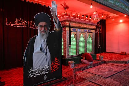 Un musulmán chiita de Cachemira reza junto a un retrato del fallecido líder supremo de Irán, el ayatollah Ali Khamenei, dentro del Imambara Zadibal, en Srinagar