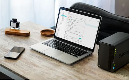 Un NAS de Synology junto a una notebook