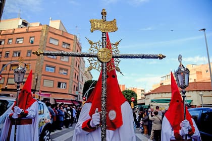 Un Nazareno con tocado cónico que lleva la Cruz de Guía durante la procesión del Domingo de Pascua