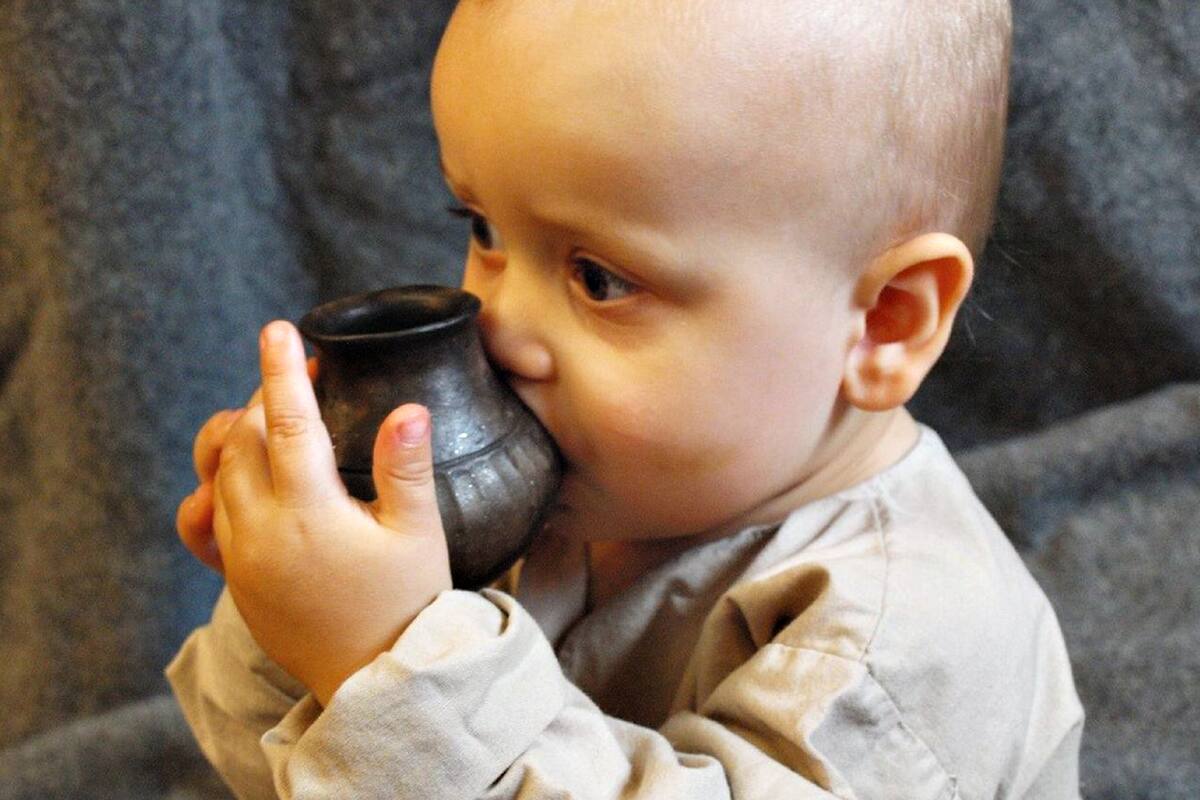 Un nene con una de las "mamaderas" prehistóricas
