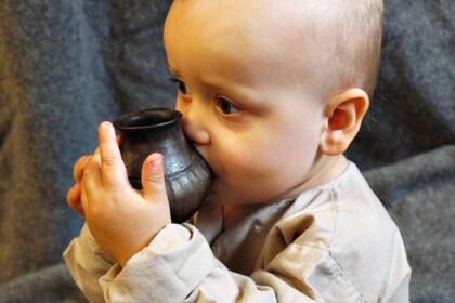 Un nene con una de las "mamaderas" prehistóricas