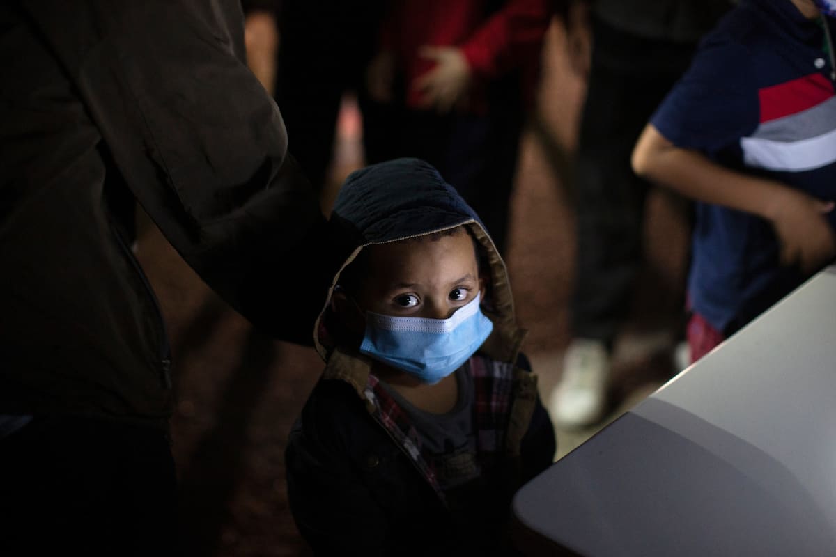 Un niño espera a responder preguntas de un agente de la Patrulla Fronteriza de Estados Unidos en un