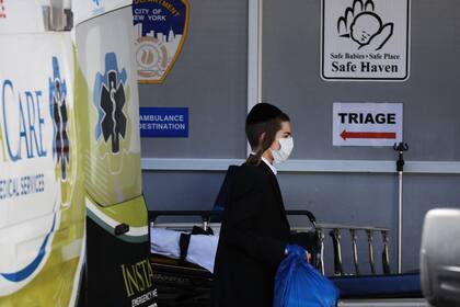 Un niño ingresa con barbijo en un hospital en Nueva York; el coronavirus no es tan agresivo con los menores; sin embargo, la muerte de tres chicos es investigada en los Estados Unidos