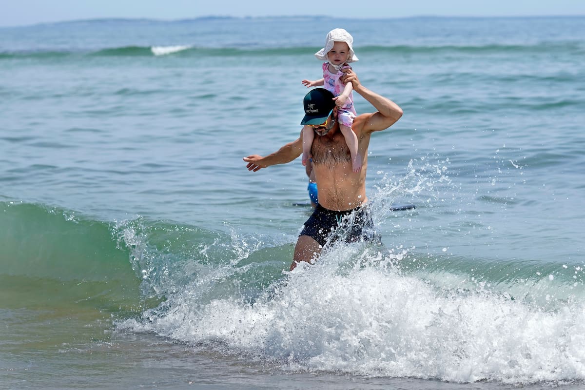 Un niño juega en el frío océano Atlántico, en Old Orchard Beach, Maine, el martes 18 de junio de 2024. (AP Foto/Robert F. Bukaty)