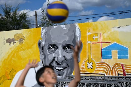 Un niño juega frente a un mural del Papa Francisco en las afueras de Sts. Catedral católica de Pedro y Pablo en Ulán Bator el 31 de agosto de 2023