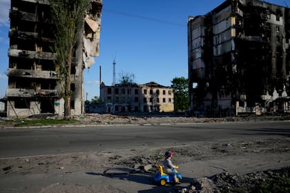 Un niño juega junto a las ruinas de su ciudad en Borodyanka, Ucrania