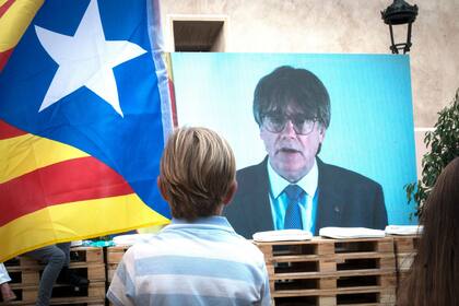 Un niño observa la intervención telemática de Puigdemont en el mitin central del partido JxCAT, a 16 de julio de 2023, en en Amer, Girona, Catalunya (España) Glòria Sánchez - Europa Press