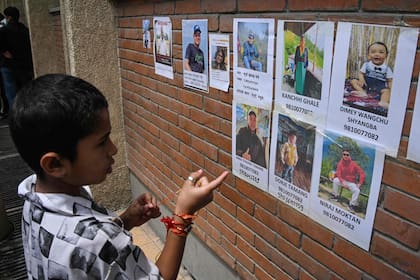 Un niño observa las fotografías de personas desaparecidas tras las inundaciones repentinas en un hospital de Katmandú el 28 de agosto de 2026.
