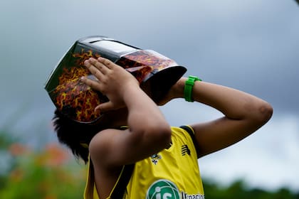 Un niño sostiene una máscara para proteger sus ojos mientras la gente se reúne para ver el eclipse anular solar en la Ciudad de Panamá, el 14 de octubre de 2023. Debido a las nubes y la lluvia el eclipse no pudo ser visible en la Ciudad de Panamá. (AP Foto/Arnulfo Franco)