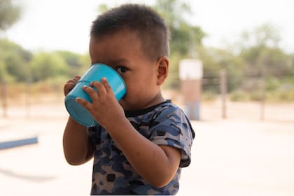 Un niño toma agua en la Escuela Nro 1034 del Lote 76, en Miraflores