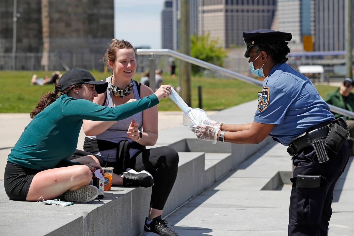 Un oficial de la policía de Nueva York ofrece toallas higiénicas en Brooklyn