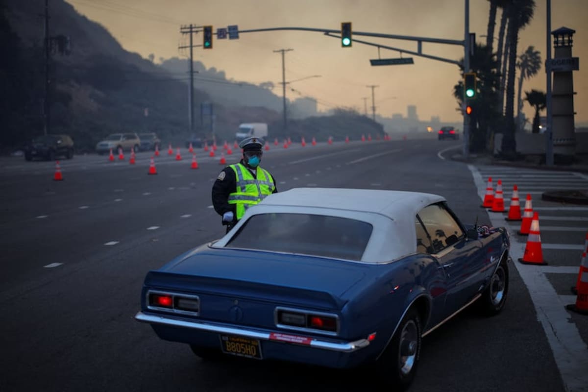 Un oficial de policía cierra el tráfico local en la zona de incendios en Los Ángeles, California, este martes 7 de enero de 2024