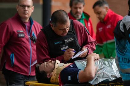 Un oficial de policía habla con un viajero que resultó herido cuando dos trenes chocaron en Buenos Aires, Argentina, el viernes 10 de mayo de 2024. (AP Foto/Natacha Pisarenko)