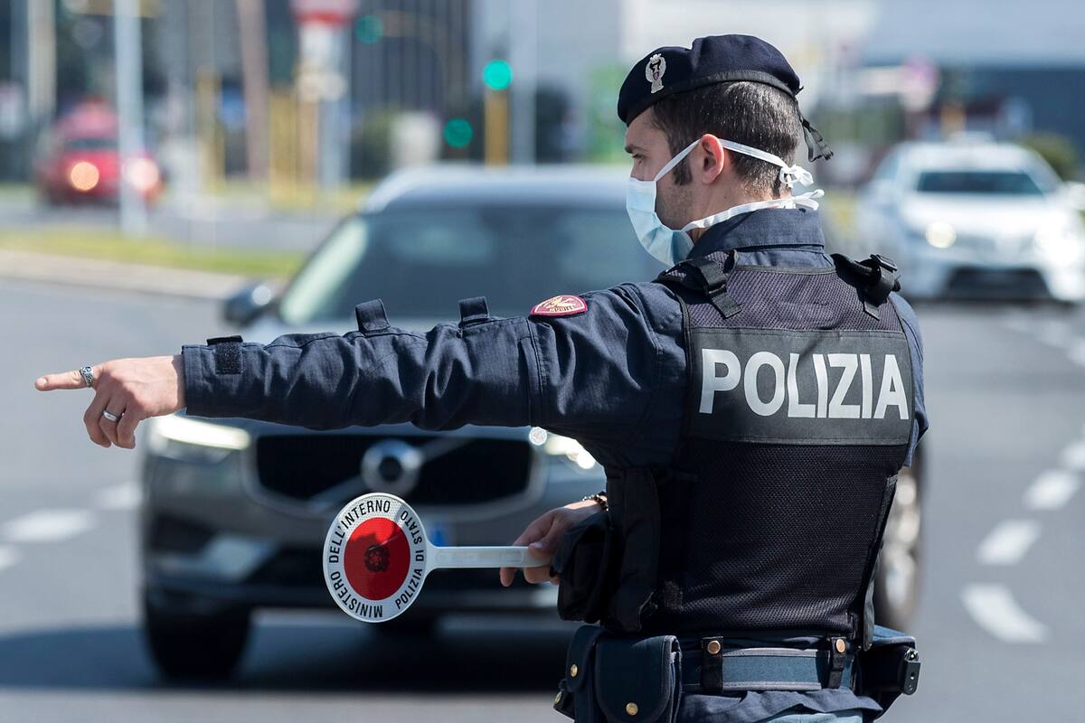 Un oficial de policía se detiene y revisa vehículos en Roma, el sábado 11 de abril de 2020. Utilizando helicópteros, drones y controles policiales intensificados para asegurarse de que los italianos no salgan de sus hogares durante el fin de semana de vacaciones de Pascua, las autoridades italianas