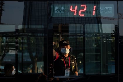 Un oficial de seguridad con un tapabocas mira desde un autobús durante la hora pico en Pekín, el 2 de septiembre pasado