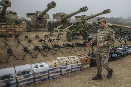 Un oficial del ejército azerbaiyano muestra armas y equipos entregados por las fuerzas armenias de Nagorno-Karabaj en el pueblo de Signag, Azerbaiyán, el domingo 1 de octubre de 2023. . (AP Photo/Aziz Karimov)