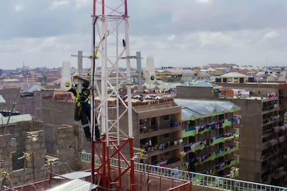 Un operario monta emisores y receptores de Taara en una antena en Kenia