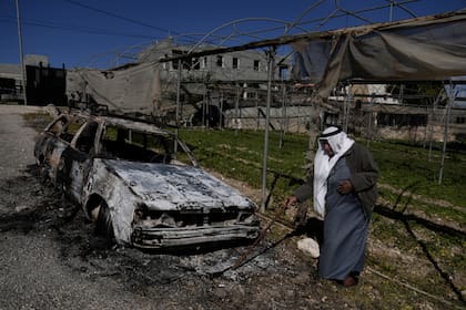 Un palestino junto a un auto incendiado tras el ataque perpetrado por presuntos colonos israelíes en la aldea de Jinsafut, en Cisjordania, el martes 21 de enero de 2025